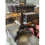 An extensively carved Anglo Indian tilt top table on triangular base. Slight split to top. W:60cm