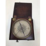 A boxed hand held 19th century compass. Wooden box with metal outer. Faintly marked to inside of lid