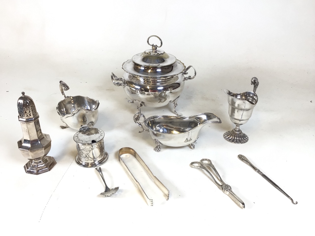 Assortment of silver plate tableware including a soup tureen, shaker, two condiment pourers, sugar