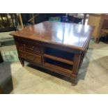 A square coffee table with drawers and shelves to sides with tapered legs and metal feet.