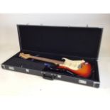 Electric guitar in hard carry case. A Squier Stratocastor by Fender.