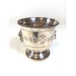 Silver plate wine bottle ice bucket, with decorative relief insert. Drop handles over lion masque