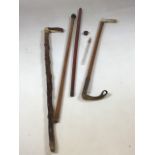 A vintage walking stick with hidden glass vial, a vintage riding crop with white metal collar, a