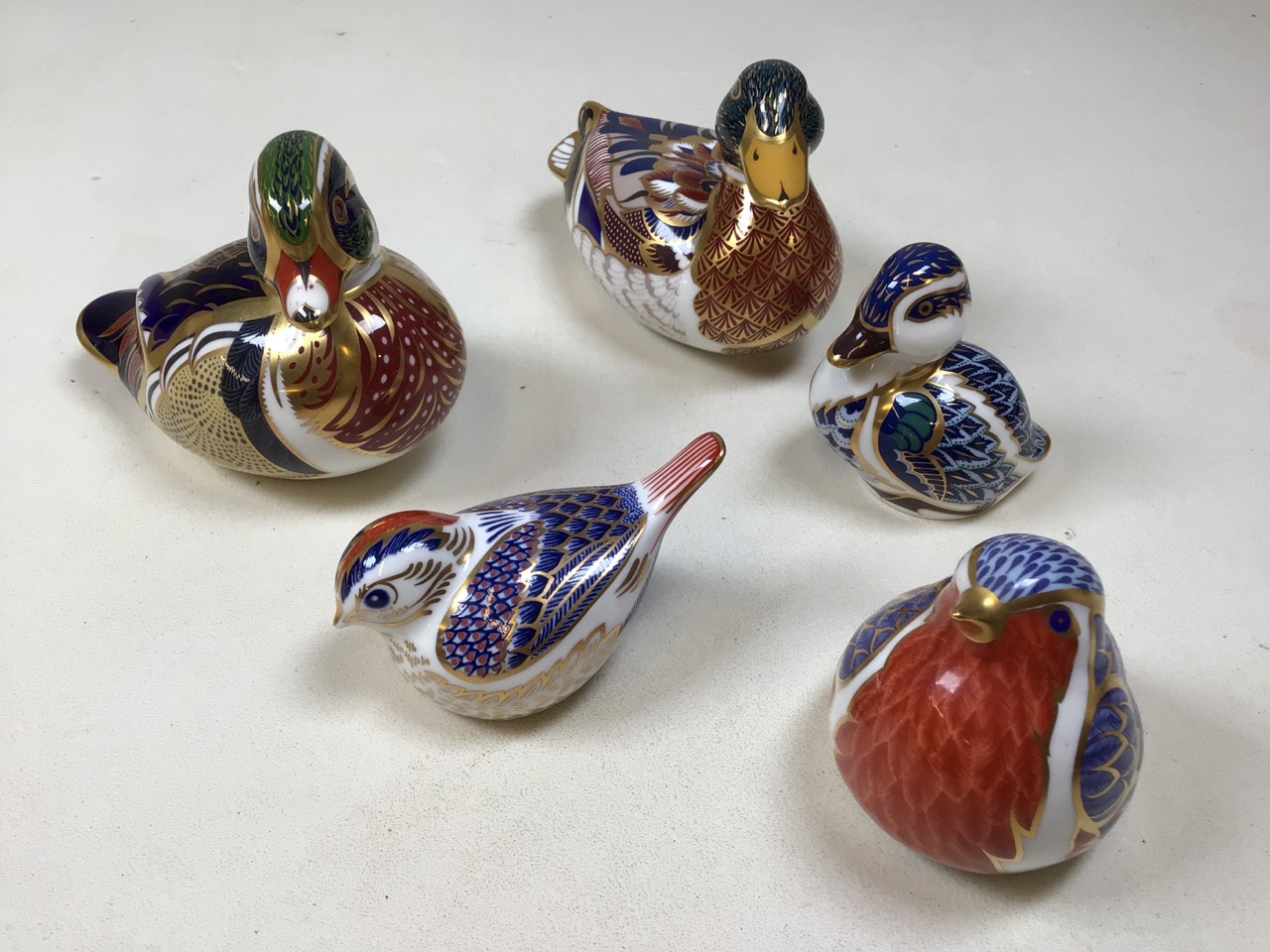 Royal Crown Derby paperweights of birds, includes three ducks and two birds. With silver and gold