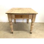 An antique pine kitchen table on turned legs and castors with drawer. W:92cm x D:85cm x H:80cm