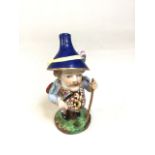A Royal Crown Derby Pot Belly Dwarf with blue hat and harlequin and flower pattern vest. Circa