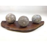 Three marble spheres on wooden plinth. W:51cm X D:20cm x H:11cm