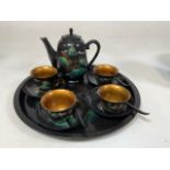 A vintage Japanese black lacquer effect tray and coffee pot, chips and saucers and spoons. Split