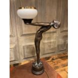An Art Deco style figural lamp on circular plinth with star design with opaque shade also with