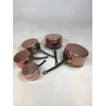 A set of five vintage copper saucepans