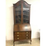 A 20th century glazed bureau bookcase with dome top glazed doors to three shelves, with bureau above