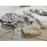 A quantity of vintage lace items including table runners, table cloth and dollies