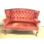 An early 20th century curved wing back sofa with button back detail.