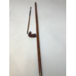 A walking stick with a smoking pipe
