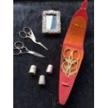 An early twentieth century embroidery scissor case with three pairs of scissors, three thimbles -