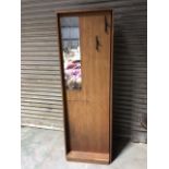 A hall cupboard with mirror and 2 hooks to outside. Door to side with interior hooks. Veneer missing