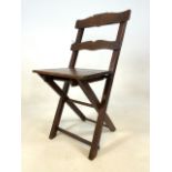 An early 20th century oak folding chair with Griffin carved into back.