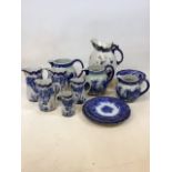 Two sets of blue and white graduated jugs one of Classical scenes the other in wild rose design