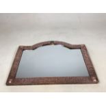 An Arts and Crafts Liberty Style hammered copper mirror with applied ceramic cabuchon detail to