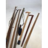 Six walking sticks, two with handles, a metre rule and a sheath knofe