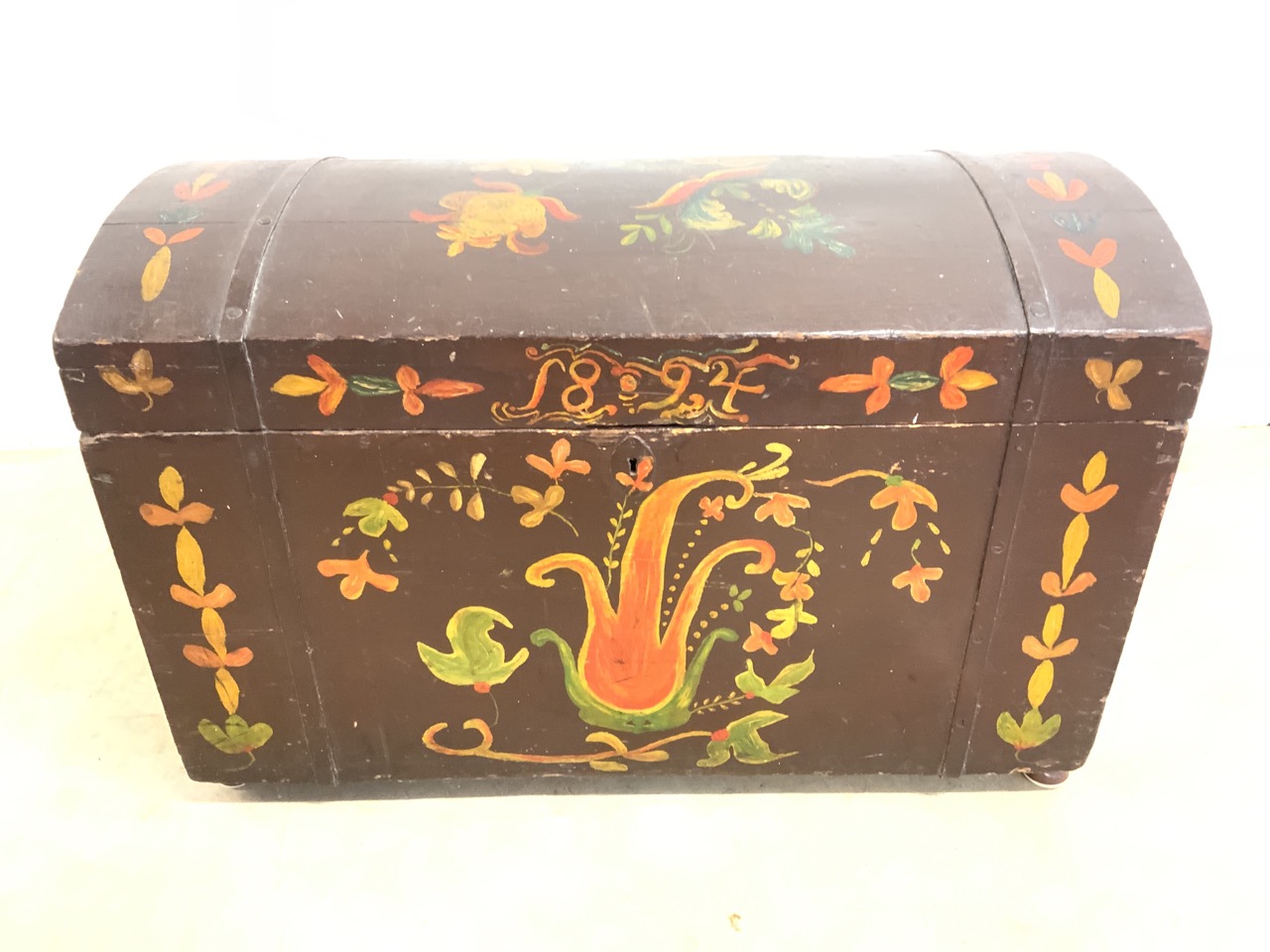 A Dome topped handpainted trunk dated 1894, naively painted with metal handles to the sides. W:
