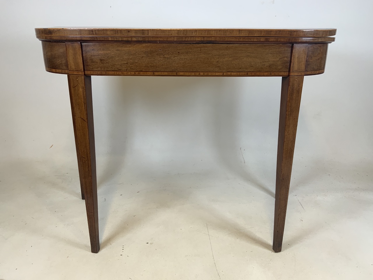 An inlaid Georgian card table with folding top to green baize. Double pull out legs.