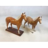 A Beswick Palamino horse set into a wooden base also with another unmarked horse H:32cm (includes