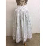 A nineteenth century hand made petticoat with one other and a vintage pair of court shoes