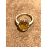 A Gold coloured ring with amber coloured stone.