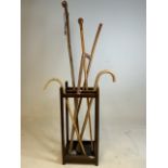 An early 20th century four section oak stick stand with metal tray to base also with a quantity of