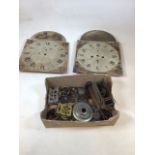 A box of clock parts including Two clock faces. Spares and repairs