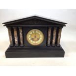 A Victorian 8 day mantle clock with architectural top supported by 6 columns on contrasting