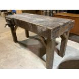 A Rustic workbench with a four plank top. With 2 inch boards, work tray to one side and vice to