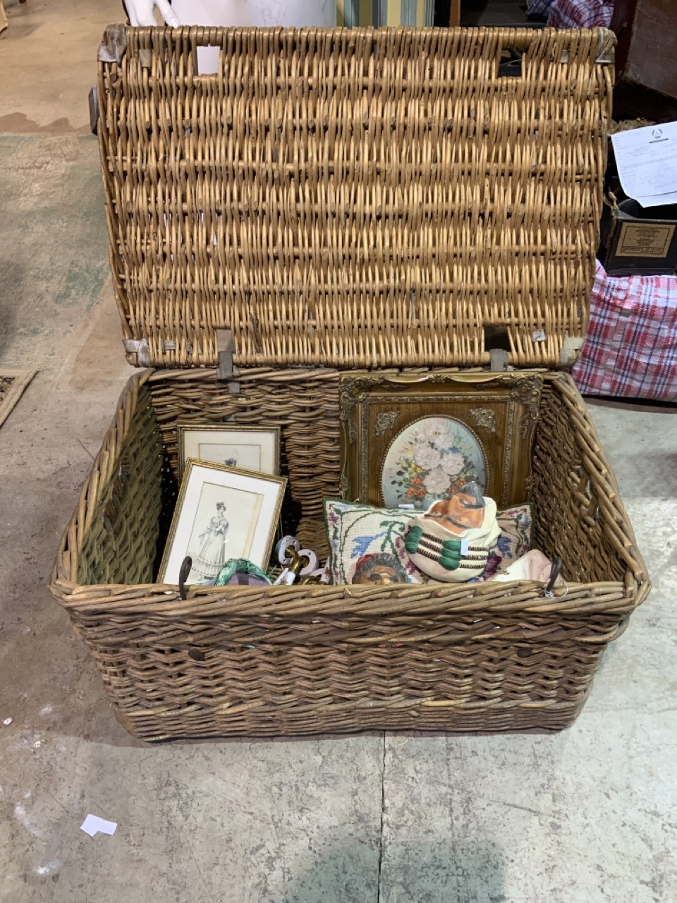 A large wicker basket with contents, ceramics and pictures etc.