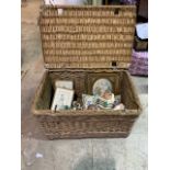 A large wicker basket with contents, ceramics and pictures etc.