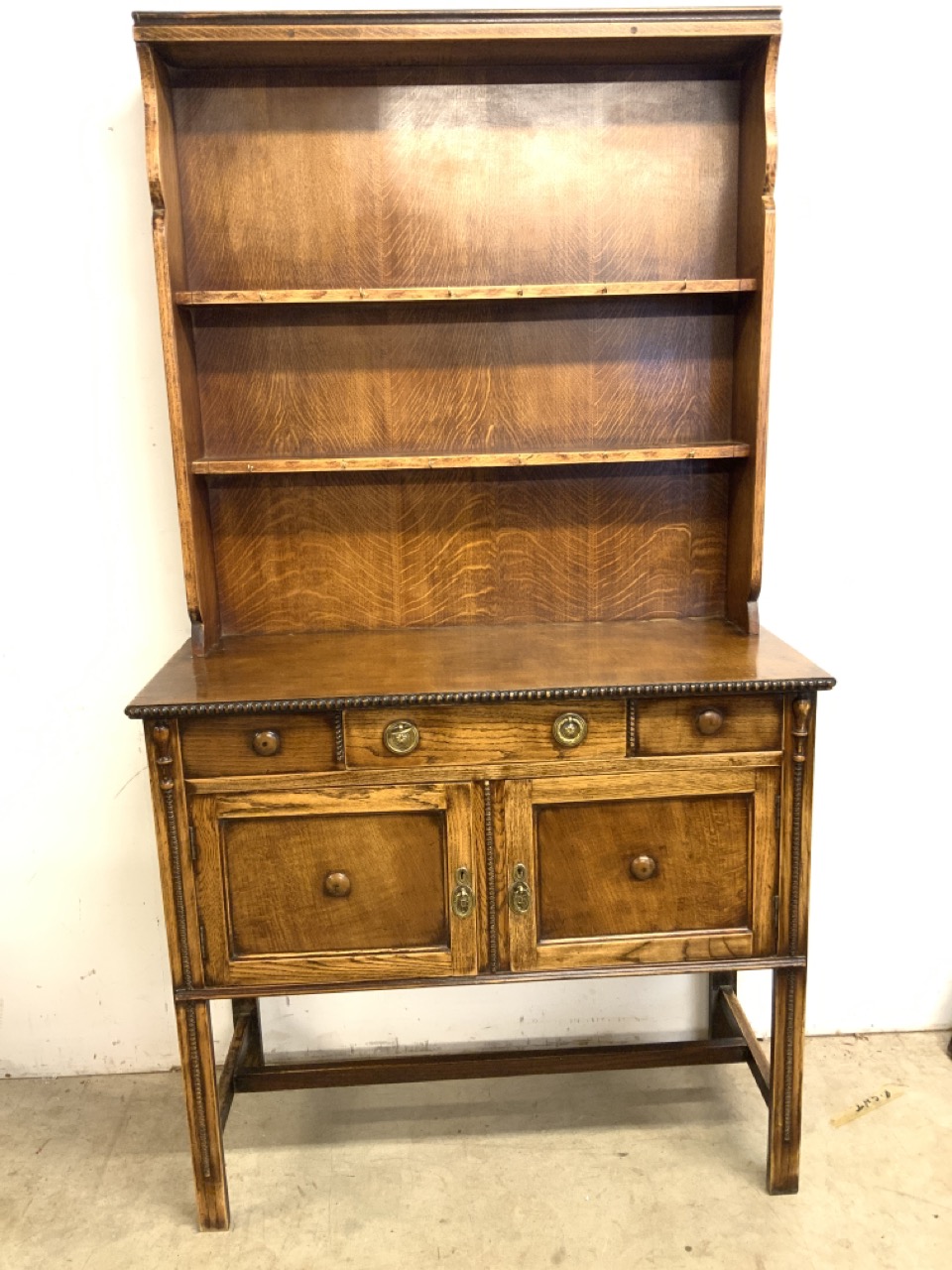 A two piece oak early 20th century dresser, base with central drawer above two cupboard, the top