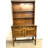 A two piece oak early 20th century dresser, base with central drawer above two cupboard, the top