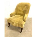 A Victorian button backed upholstered nursing char with turned legs and ceramic and brass castors.