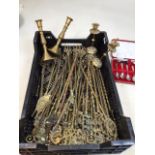 A crate of brass and other metal toasting forks, brass candlesticks and other s