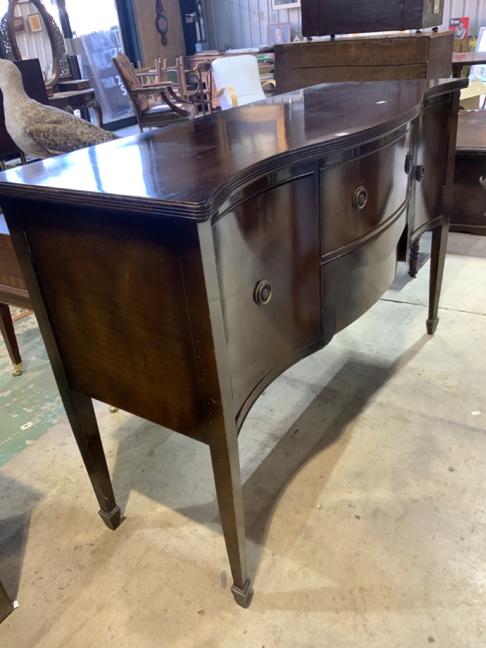 A serpentine fronted sideboard, 20th century, two middle drawers flanked by cupboards. W:141cm x D: