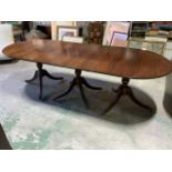 A triple pillar mahogany veneered reproduction dining table. With brass twist clips and wooden