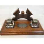 An Edwardian oak ink stand, glass bottles with silver plated tops. Engraved plaque to front and back