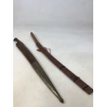 Two long bladed weapons. One with a curved blade and a wooden sheath, handle bound with string