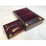 A rosewood Writing slope with secret drawer which reveals a pistol, a copper and brass powder flask,