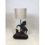 A bronzed spelter table lamp depicting a man holding a rearing horse W:38cm x H:67cm