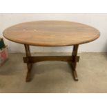 A golden oak drop flap table. Extended forms an circle. With large pegged stretcher to base. W:120cm