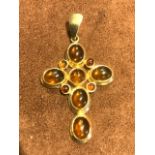 A gold coloured and faux amber cross. Height of cross 4cm