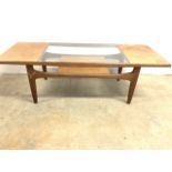 A mid century teak G Plan coffee table with glass insert and lower shelf. W:137cm x D:51cm x H:43cm