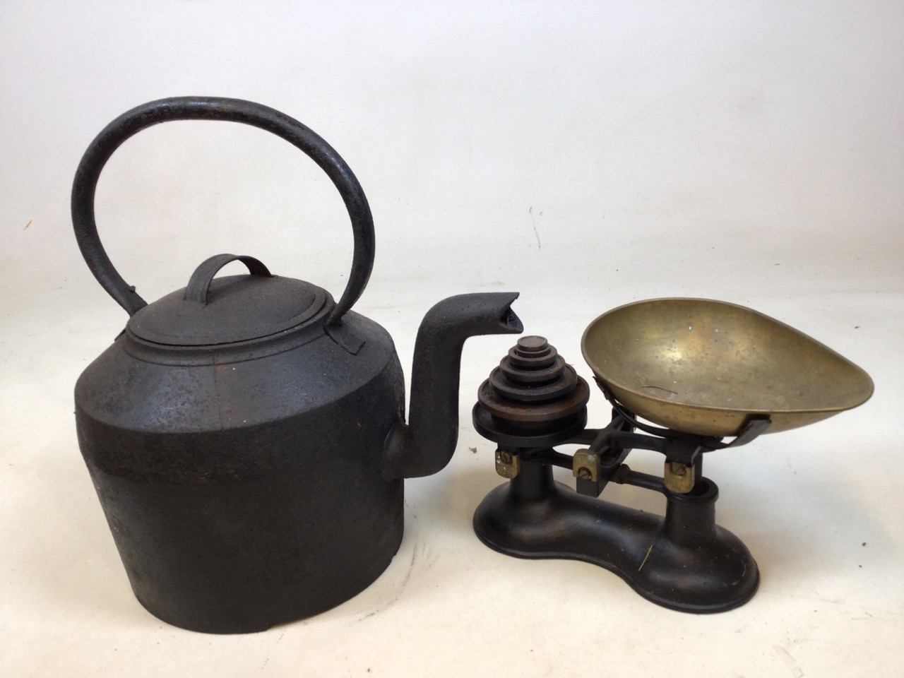 A large, heavy cast iron kettle and a set of scales with weights H:47cm including handle