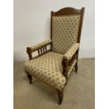 An early 20th century oak library chair with upholstery back, seat and arms, with turned details and